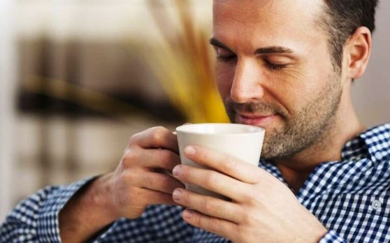 एक आदमी शक्ति बढ़ाने के लिए फायरवीड चाय का एक पेय पीता है